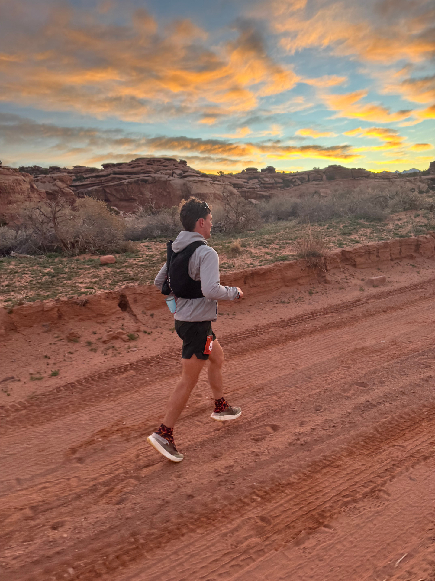Levi running through the red desert at sunrise